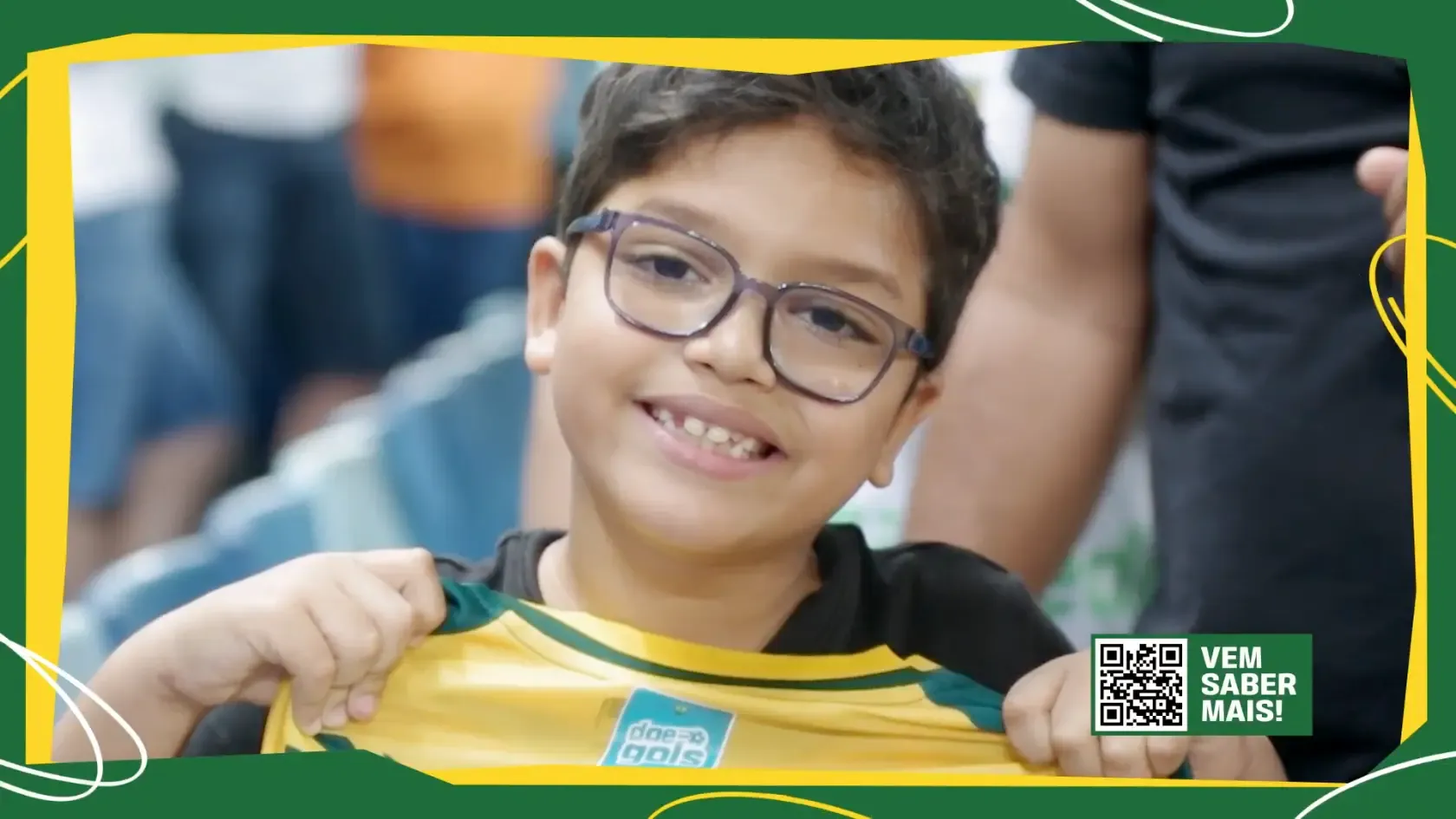 Criança sorridente exibe camisa com o patch do Doe Gols nas arquibancadas da Arena Pantanal, durante o Jogo Doe Gols do Cuiabá.