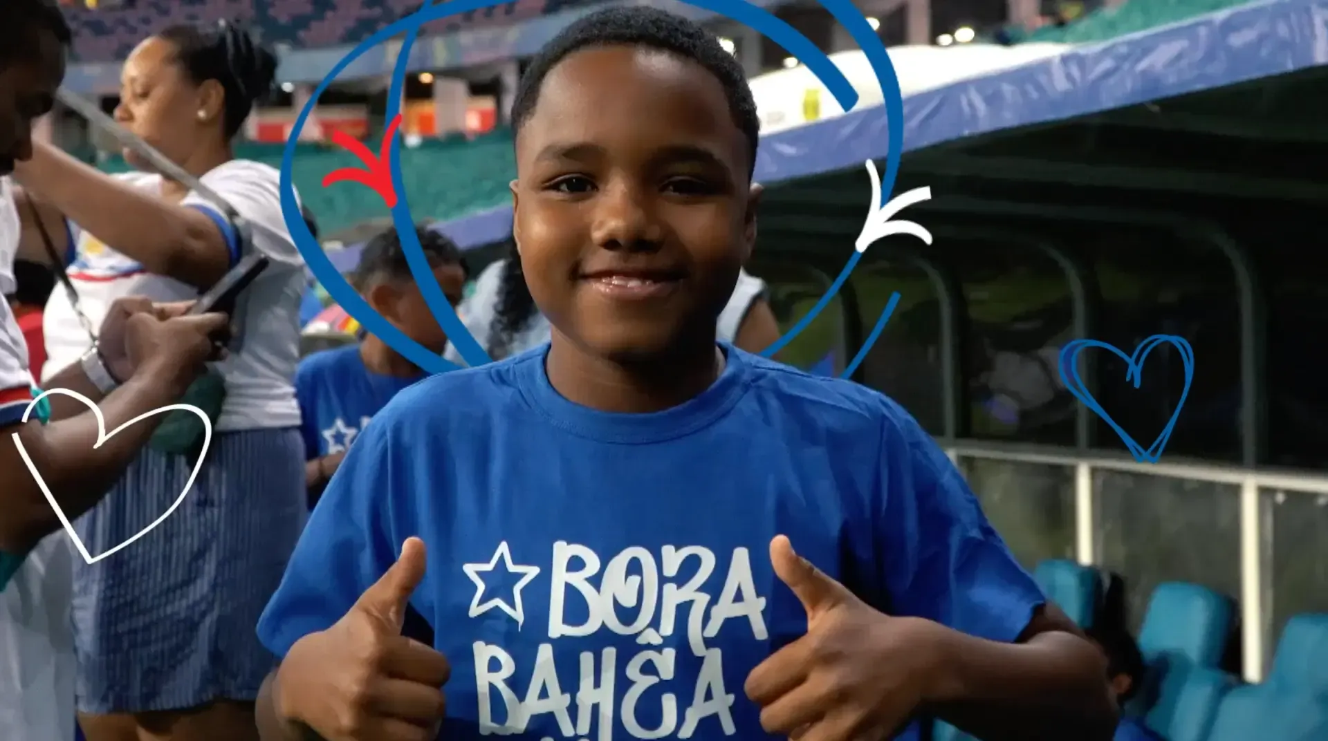 Criança com camiseta "Bora Bahea" faz joinha sorrindo nas arquibancadas da Arena Fonte Nova, durante o Jogo Doe Gols do Bahia.